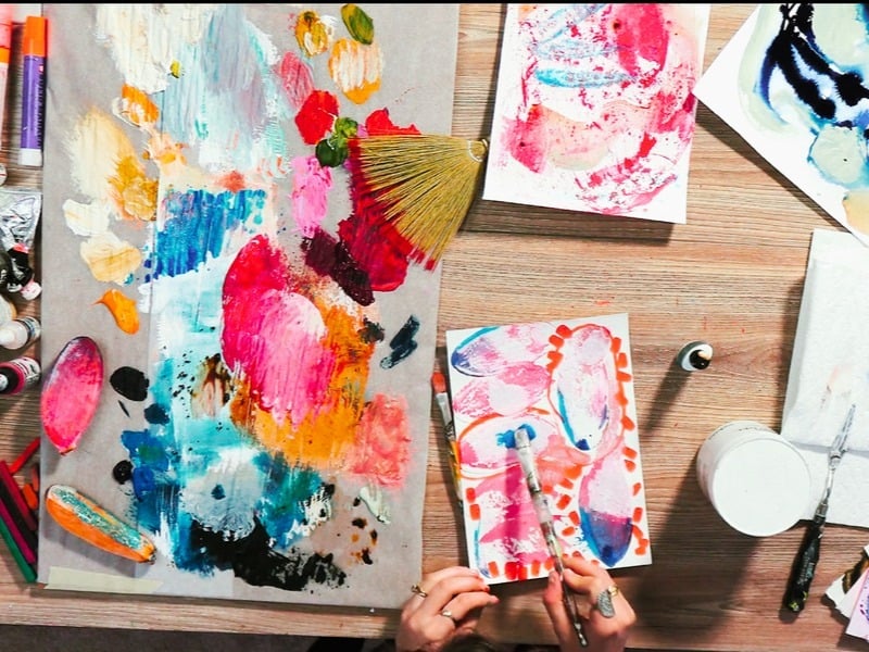 Overhead desk with small bright watercolor art hand painting